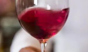 Un bicchiere di vino rosso vibrante, quasi in movimento, pronto per essere raffreddato.