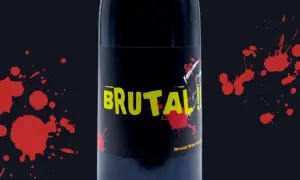 Bottiglia di vino "Brutal" con etichetta nera e gialla, macchie rosse che ricordano il sangue. Esistono vini senza solfiti, come questo.