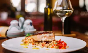 Salmone croccante su couscous con peperoni rossi. Un'idea perfetta su cosa abbinare al salmone, accompagnato da un bicchiere di vino bianco.