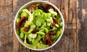 Insalata fresca con fave, pomodori secchi e lattuga. Le fave sono legumi nutrienti, perfetti per un piatto leggero e gustoso.