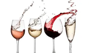 Un brindisi con calici di vino rosato, bianco, rosso e spumante, con schizzi dinamici che creano un'atmosfera festosa.