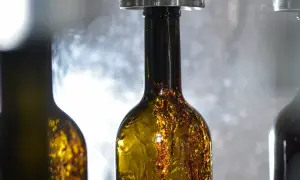 Bottiglie di vino ambrato in fase di imbottigliamento, un momento cruciale nel calendario per imbottigliare il vino.