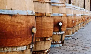 File di botti di legno in fila, pronte per la maturazione. La loro capacità barrique è fondamentale per il vino.