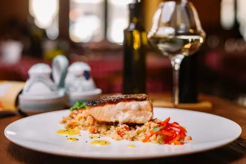 Salmone croccante su couscous con peperoni rossi. Un'idea perfetta su cosa abbinare al salmone, accompagnato da un bicchiere di vino bianco.