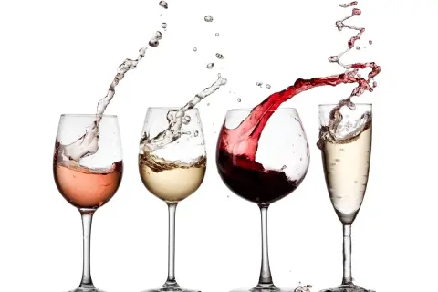 Un brindisi con calici di vino rosato, bianco, rosso e spumante, con schizzi dinamici che creano un'atmosfera festosa.