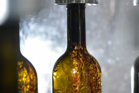 Bottiglie di vino ambrato in fase di imbottigliamento, un momento cruciale nel calendario per imbottigliare il vino.