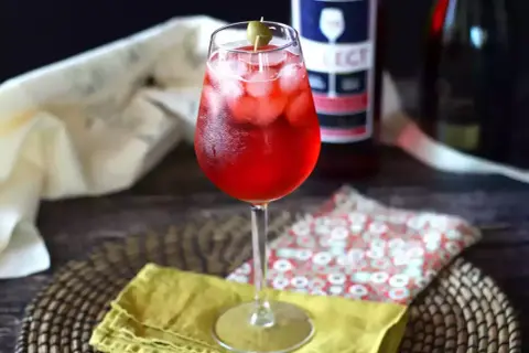 Un bicchiere di Spritz Select, con ghiaccio e oliva, pronto per essere gustato. La ricetta perfetta per un aperitivo rinfrescante.