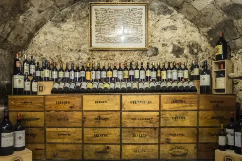 Cantina con bottiglie di vino e casse di legno, un ambiente che garantisce l'umidità ideale cantina vini per la conservazione.