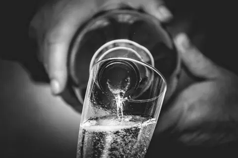 Versando bollicine in un bicchiere, un brindisi che evoca il metodo Charmat.