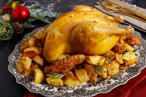Un succulento cappone cos'è? Un arrosto dorato su un letto di patate croccanti, guarnito con rosmarino, pronto per le feste.