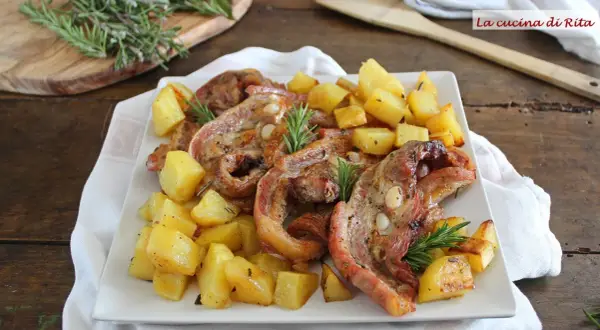 Piatto di petto di vitella arrosto con patate croccanti e rosmarino. Un classico saporito.