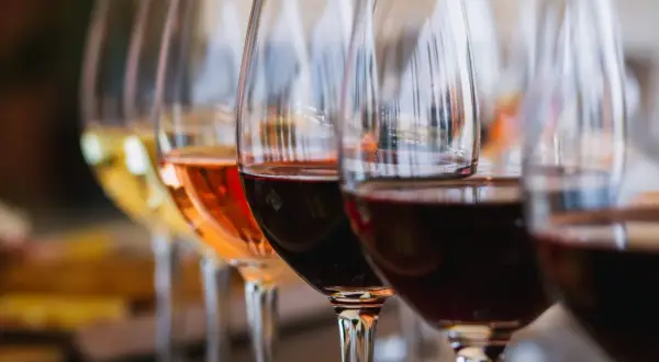 Calici di vino bianco, rosato e rosso, un viaggio attraverso la storia del vino.