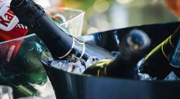 Bottiglie di vino per matrimonio in un secchiello con ghiaccio, pronte per essere stappate.