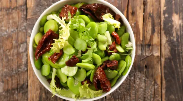 Insalata fresca con fave, pomodori secchi e lattuga. Le fave sono legumi nutrienti, perfetti per un piatto leggero e gustoso.