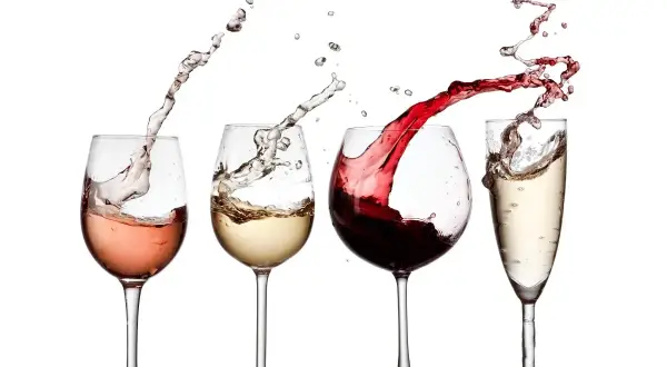 Un brindisi con calici di vino rosato, bianco, rosso e spumante, con schizzi dinamici che creano un'atmosfera festosa.