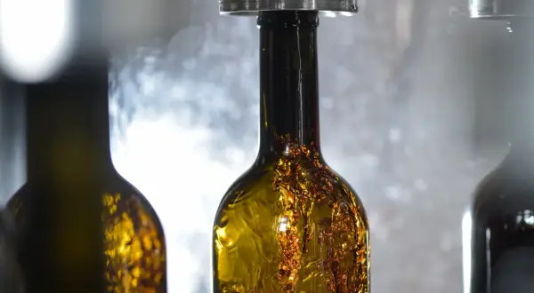 Bottiglie di vino ambrato in fase di imbottigliamento, un momento cruciale nel calendario per imbottigliare il vino.