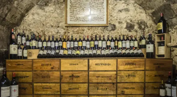 Cantina con bottiglie di vino e casse di legno, un ambiente che garantisce l'umidità ideale cantina vini per la conservazione.