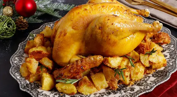 Un succulento cappone cos'è? Un arrosto dorato su un letto di patate croccanti, guarnito con rosmarino, pronto per le feste.