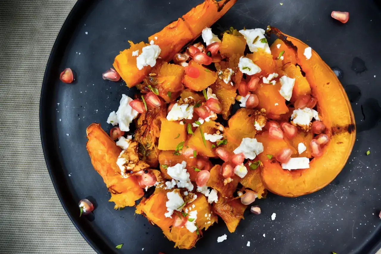 Insalata di zucca arrosto con feta, melograno e noci. Un piatto autunnale che celebra i sapori e gli abbinamenti con la zucca.