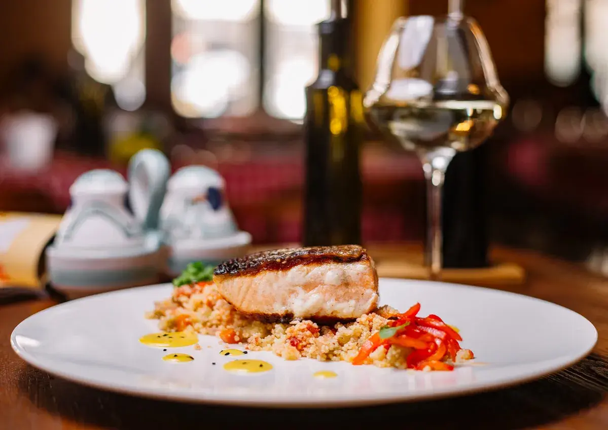 Salmone croccante su couscous con peperoni rossi. Un'idea perfetta su cosa abbinare al salmone, accompagnato da un bicchiere di vino bianco.