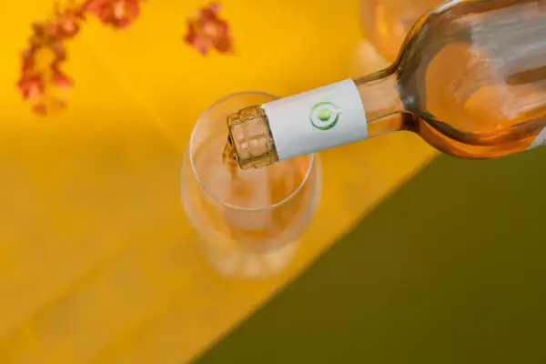 Versando vino rosato in un calice, perfetto per scoprire i suoi abbinamenti con piatti leggeri e freschi.