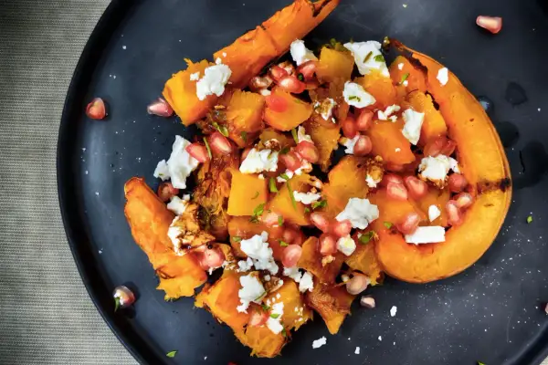 Insalata di zucca arrosto con feta, melograno e noci. Un piatto autunnale che celebra i sapori e gli abbinamenti con la zucca.