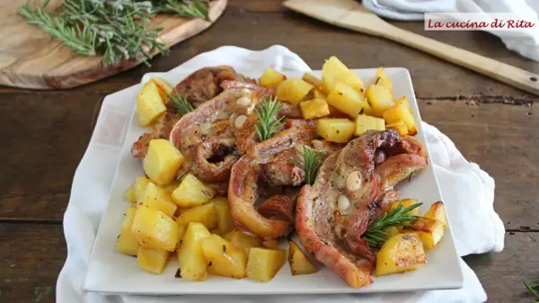 Piatto di petto di vitella arrosto con patate croccanti e rosmarino. Un classico saporito.
