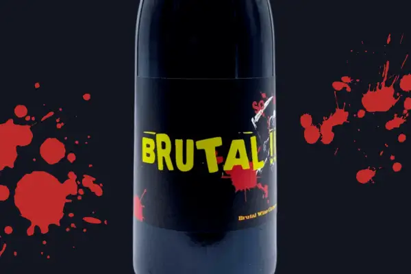 Bottiglia di vino "Brutal" con etichetta nera e gialla, macchie rosse che ricordano il sangue. Esistono vini senza solfiti, come questo.
