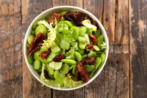 Insalata fresca con fave, pomodori secchi e lattuga. Le fave sono legumi nutrienti, perfetti per un piatto leggero e gustoso.