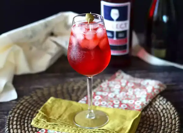 Un bicchiere di Spritz Select, con ghiaccio e oliva, pronto per essere gustato. La ricetta perfetta per un aperitivo rinfrescante.
