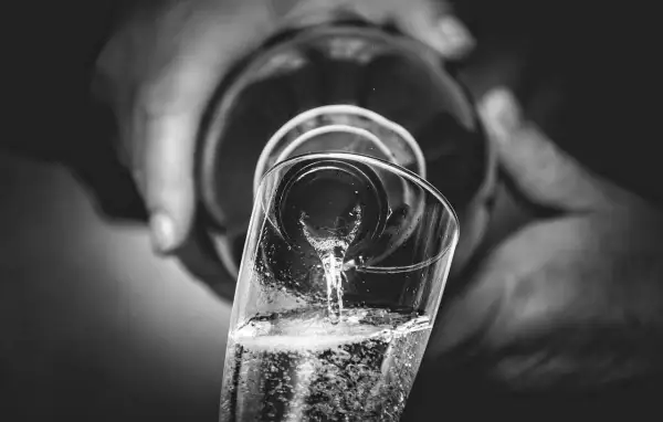 Versando bollicine in un bicchiere, un brindisi che evoca il metodo Charmat.